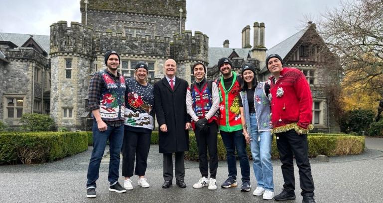President Philip Steenkamp posted with students and staff, all dressed in holiday sweaters.