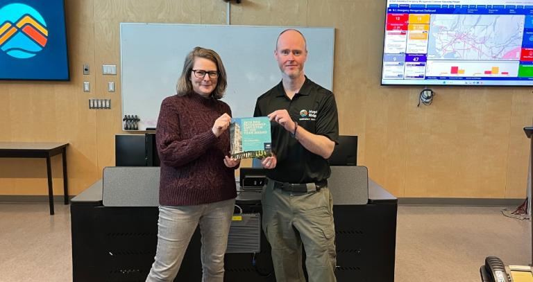 Dawn Varley and Edd Bennett standing in a boardroom hold Internship of the Year award.