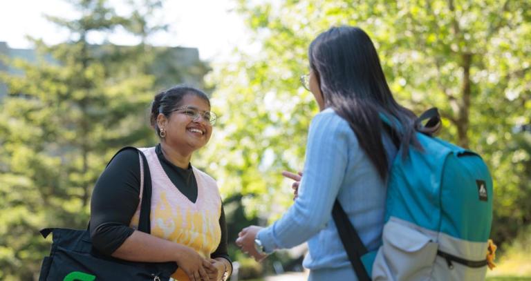 Two students speaking on university campus