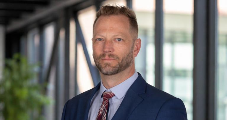 James Hanson wearing a suit and standing in a modern building