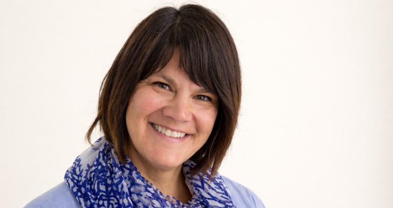 Kelly Terbasket smiling in front of a white background