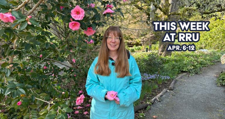 Woman standing in front of blossoming plant in garden