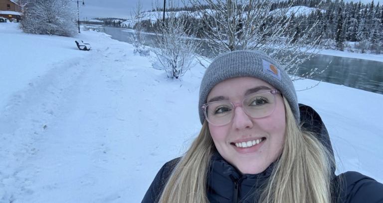 Asia McLean smiling in front of a snowy river background