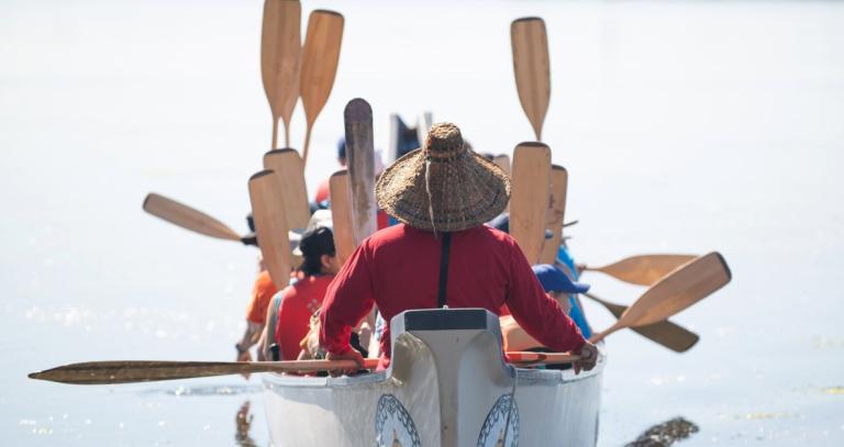 A group of people in a canoe on calm waters