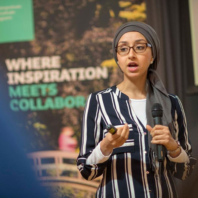Student-presenting-in-front-of-Where-Inspiration-Meets-Collaboration-sign