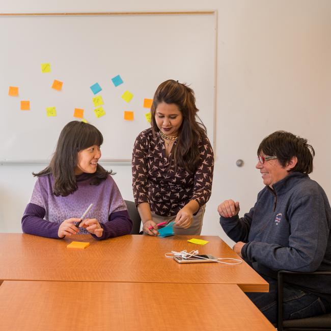 Three people working with sticky notes