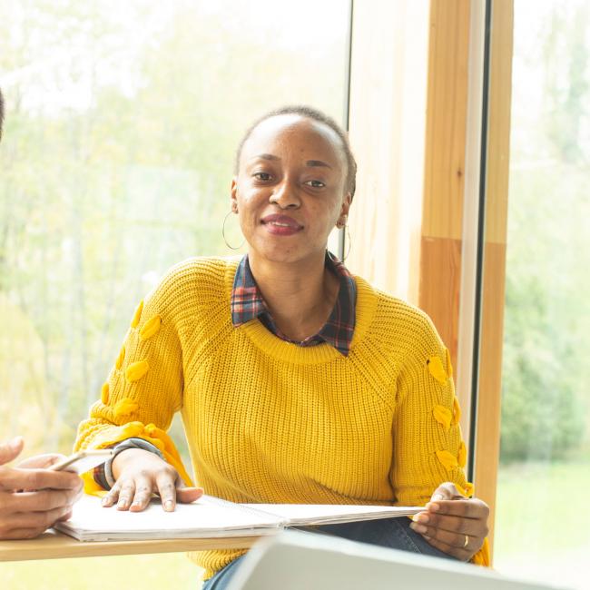 Woman in bright yellow sweater working