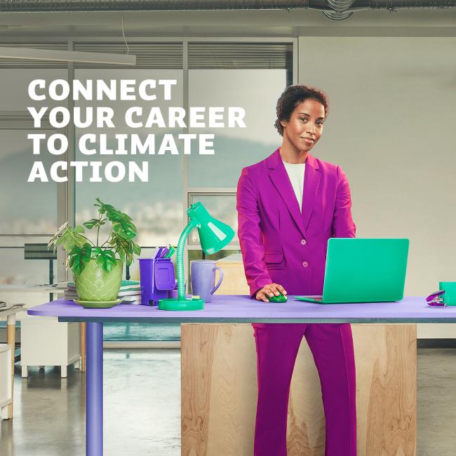 A woman stands in front of a colourful desk in an office. 