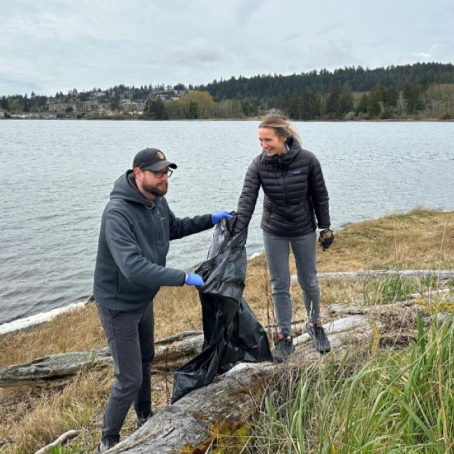 People removing litter from lagoon shore on campus