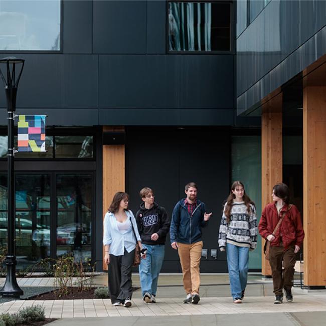 Students walk in a line together in front of Royal Roads John Horgan Campus.