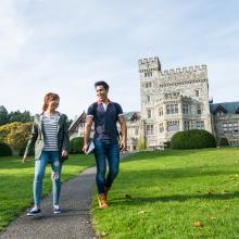 Two students walking on campus by Hatley Castle