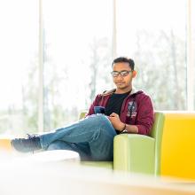Student sitting in bright green chair, with yellow