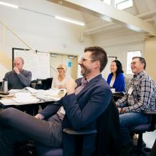 Group-sitting-around-board-table-laughing-and-engaged