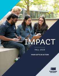 Four students gathered around 2 individuals reading a book and a laptop in an outdoor setting