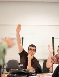 Students in class with hands raised