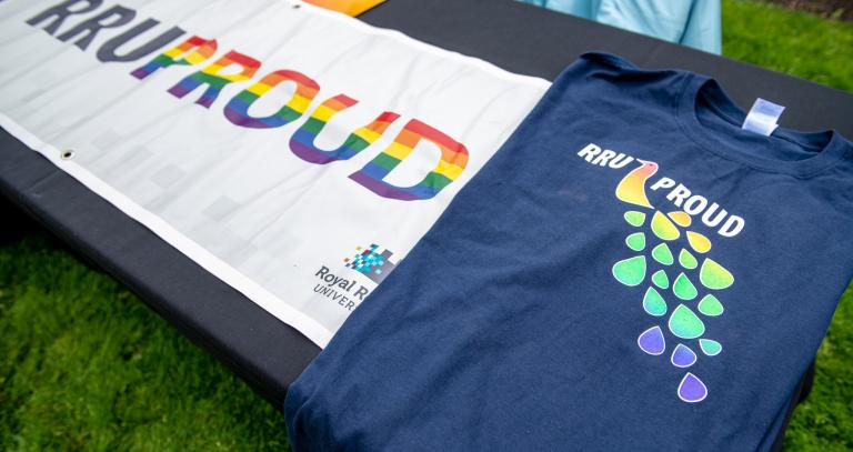 A banner and t-shirt both with the words RRU Proud